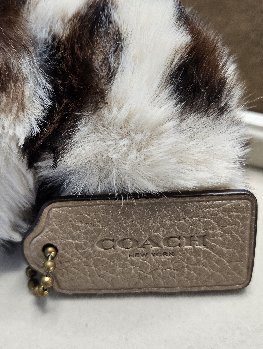 Coach Textured Taupe Leather Tag with White and Brown Fur Puff Keychain